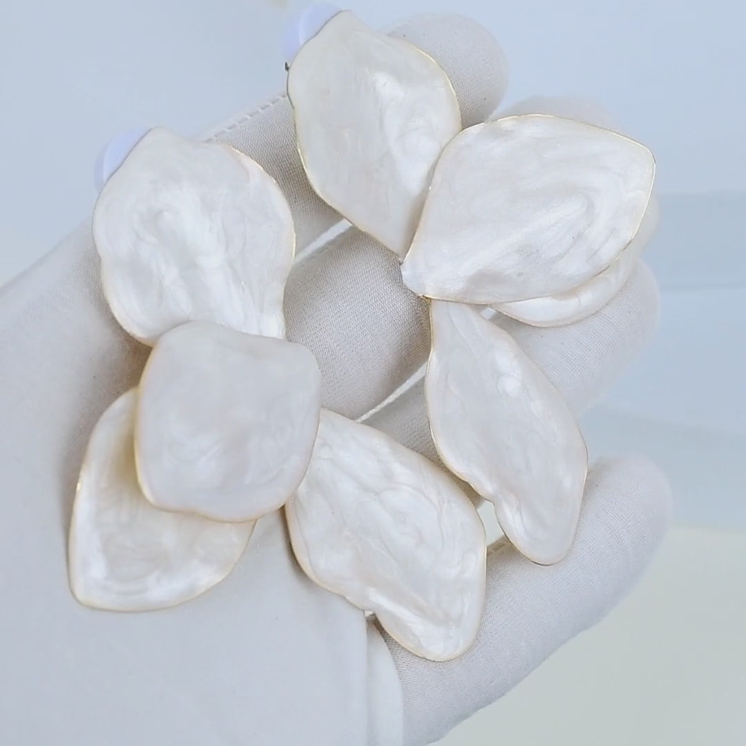video of the Luxury-inspired oversized flower earrings with luminous enamel detailing in hand 