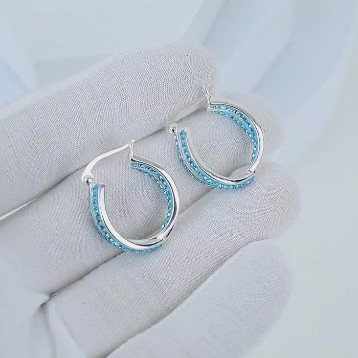 Video showcasing the dimensional dual-band split design and intense light reflection of the Cyan Glace hoop earrings