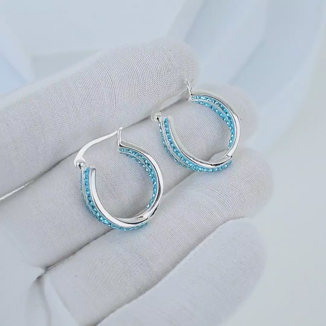 Video showcasing the dimensional dual-band split design and intense light reflection of the Cyan Glace hoop earrings