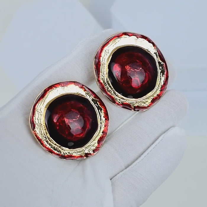 Vintage-inspired red and gold clip-on earrings with circular silhouettes and textured metal borders by Civaro.
