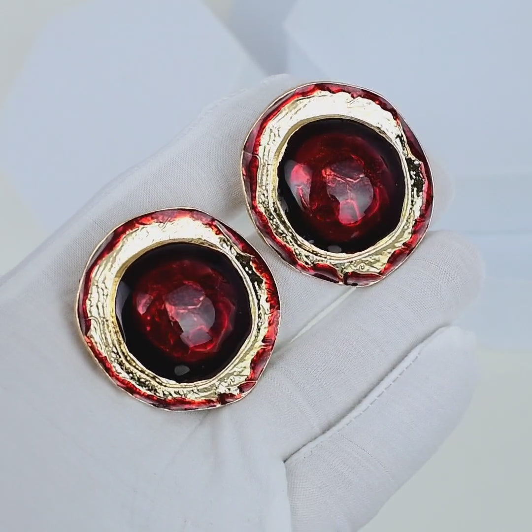 Vintage-inspired red and gold clip-on earrings with circular silhouettes and textured metal borders by Civaro.
